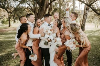 Bride and Groom kiss during bridal party photo session at Hunter Valley wedding venue The Woodhouse Wollombi