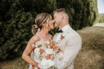 Bride and Groom kiss amoungst the grounds of Hunter Valley wedding venue The Woodhouse Wollombi