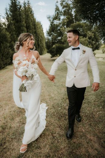 Bride and Groom walking holding hands inside the grounds of Hunter Valley wedding venue The Woodhouse Wollombi52