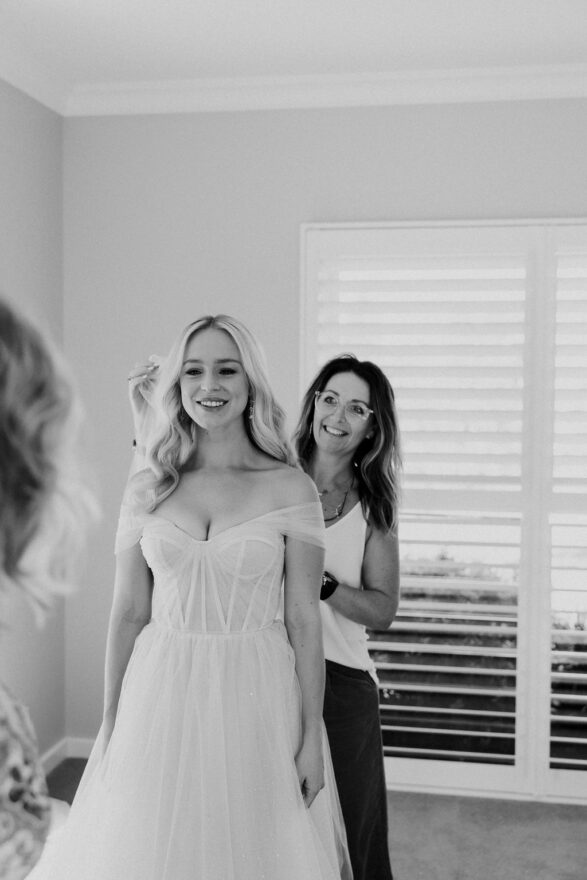 Hunter Valley wedding hair stylist places brides veil in hair on her wedding day