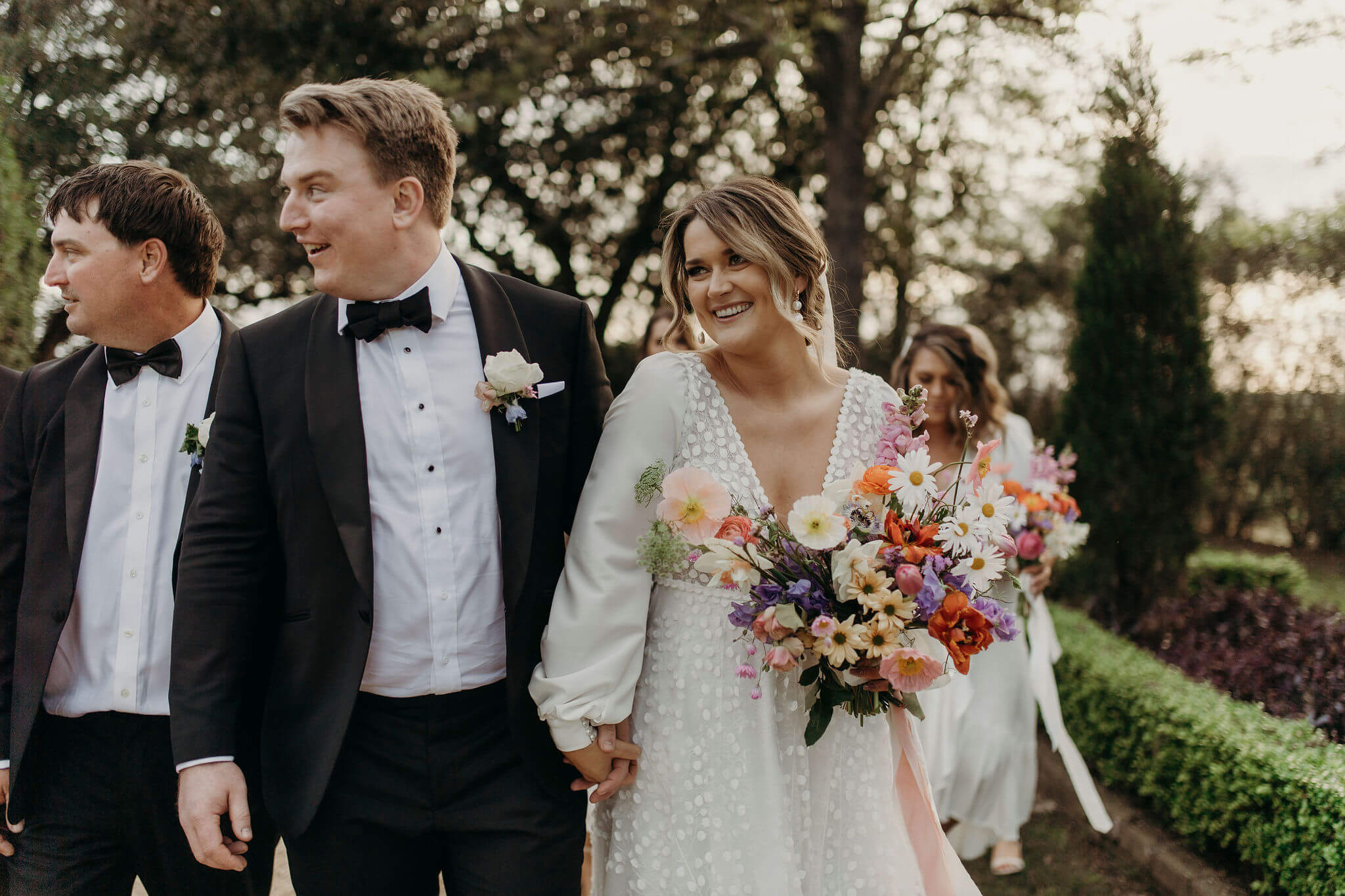 Bride on her wedding day holding colourful bunch of flowers